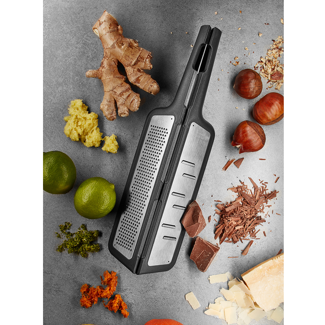 Divdaļīga salokāma rīve Gefu uz pelāka galda ar ingveru, laimiem, šokolādi un cieto sieru.