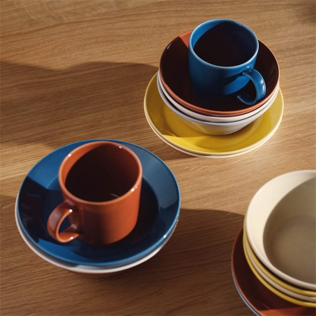 Linu krāsas trauki kombinācijā ar retro brūnas un retro zilas krāsas porcelāna traukiem uz koka galda